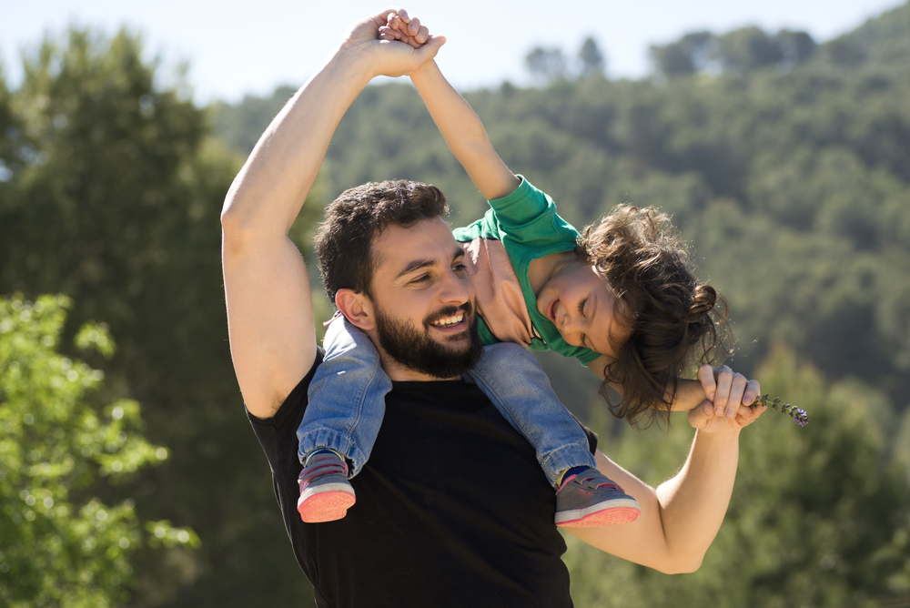 Father carrying his child on his shoulders outdoors